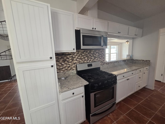 5121 Juliandra Ave, El Paso, TX 79924 - kitchen with appliances with stainless steel finishes, dark tile patterned flooring, backsplash, white cabinetry, and a ceiling fan