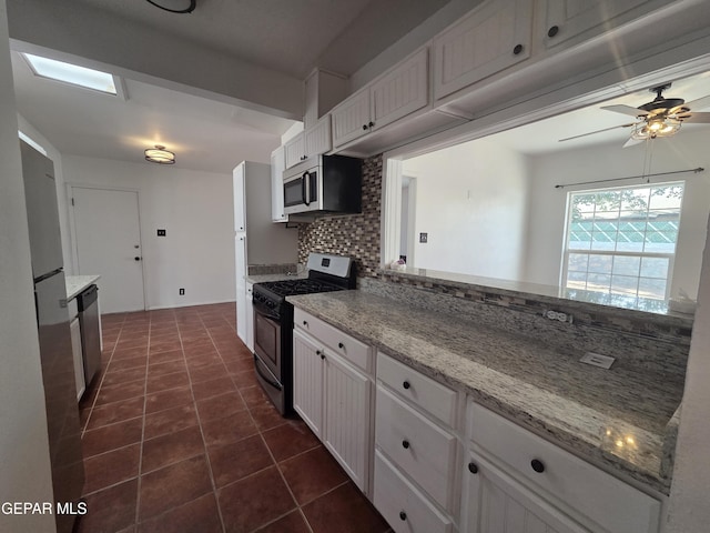 5121 Juliandra Ave, El Paso, TX 79924 - kitchen featuring stainless steel appliances, backsplash, white cabinetry, and dark tile patterned floors