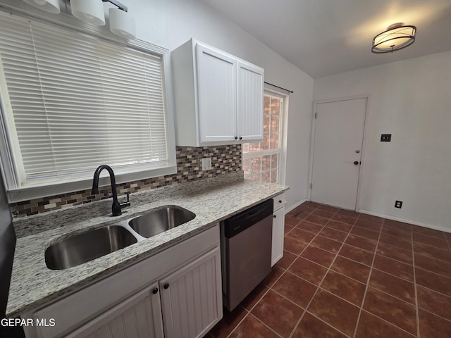 5121 Juliandra Ave, El Paso, TX 79924 - kitchen featuring stainless steel dishwasher, dark tile patterned flooring, a sink, decorative backsplash, and white cabinets
