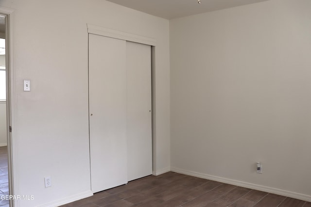 10544 Olga St, El Paso, TX 79924 - unfurnished bedroom featuring dark wood finished floors, a closet, and baseboards