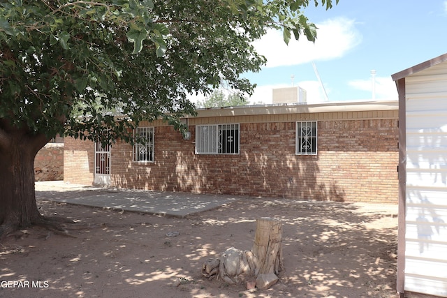 10544 Olga St, El Paso, TX 79924 - view of side of home with brick siding and a patio