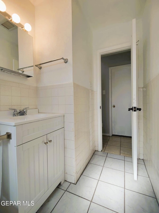10077 Kirwood St, El Paso, TX 79924 - bathroom with tile walls, vanity, tile patterned floors, and wainscoting