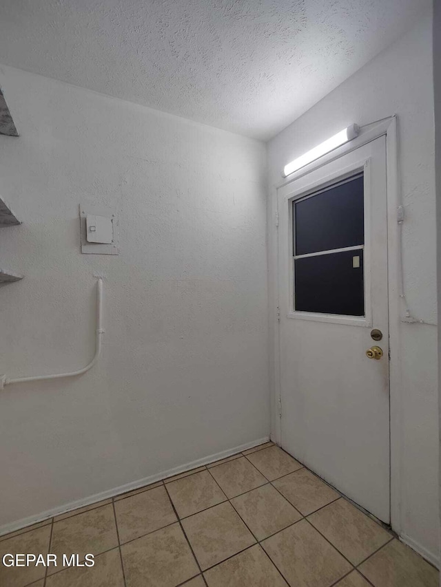 10077 Kirwood St, El Paso, TX 79924 - empty room with light tile patterned floors, a textured ceiling, and baseboards