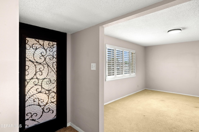 8213 Mineola Dr, El Paso, TX 79925 - foyer featuring carpet flooring, a textured ceiling, and baseboards