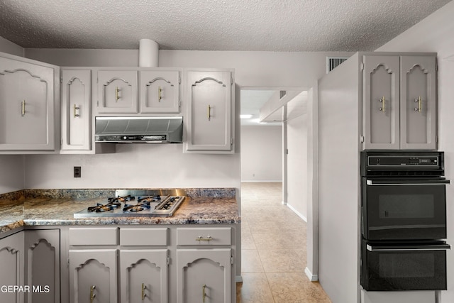 8213 Mineola Dr, El Paso, TX 79925 - kitchen featuring under cabinet range hood, stainless steel gas cooktop, a textured ceiling, gray cabinets, and light tile patterned flooring