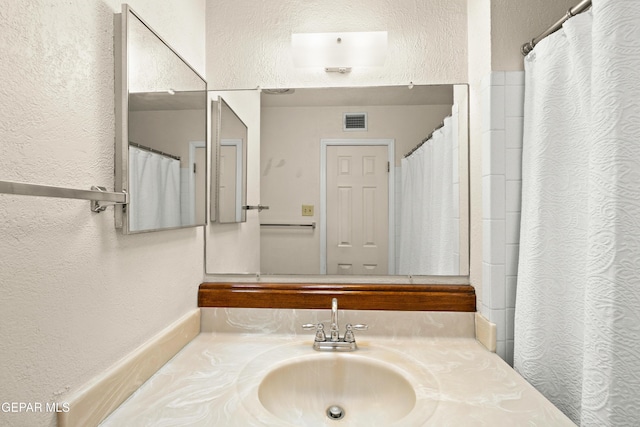 8213 Mineola Dr, El Paso, TX 79925 - bathroom featuring a textured wall and vanity