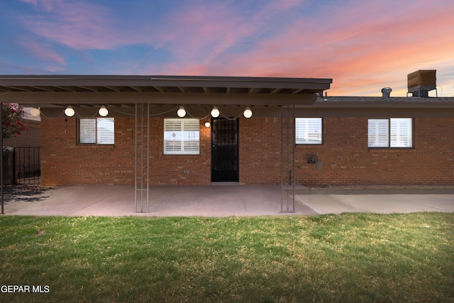 8213 Mineola Dr, El Paso, TX 79925 - back of property at dusk featuring brick siding and a patio