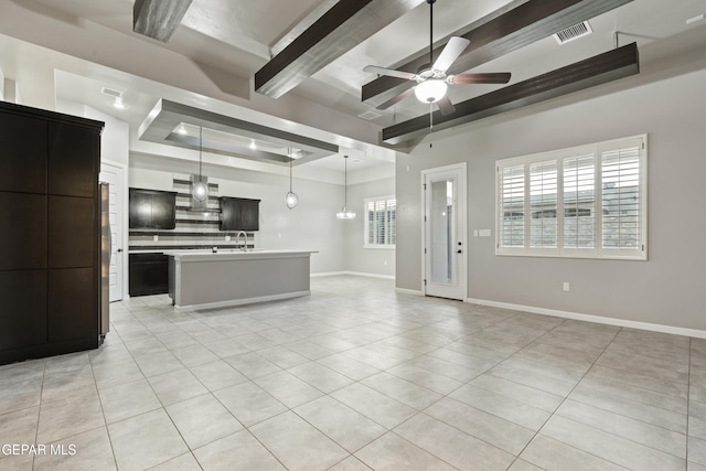 12287 Houghton Spgs, Horizon City, TX 79928 - unfurnished living room with a raised ceiling, a ceiling fan, light tile patterned floors, beamed ceiling, and baseboards