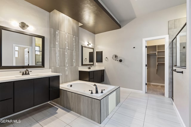 12287 Houghton Spgs, Horizon City, TX 79928 - bathroom with tile patterned floors, two vanities, a garden tub, a spacious closet, and baseboards