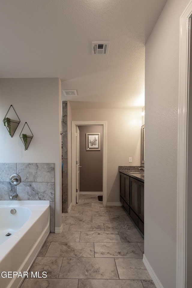 12301 Desert Heights Ct, El Paso, TX 79938 - full bathroom featuring a garden tub, vanity, and marble look tile flooring