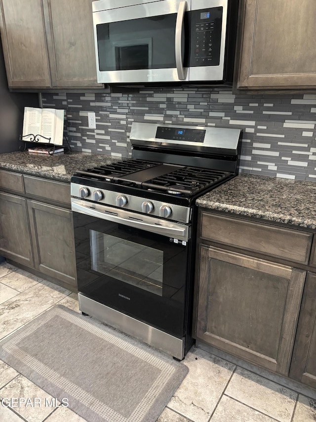 12301 Desert Heights Ct, El Paso, TX 79938 - kitchen featuring stainless steel appliances, dark brown cabinets, decorative backsplash, and dark stone countertops