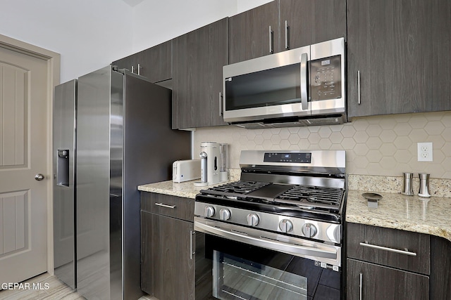 533 Cedarwood Ave, El Paso, TX 79928 - kitchen with appliances with stainless steel finishes, dark brown cabinets, backsplash, and light stone countertops