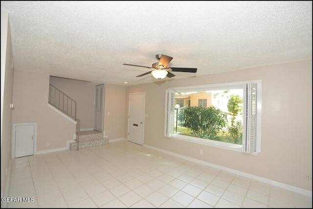 212 Paso Noble Dr, El Paso, TX 79912 - spare room with a ceiling fan, a textured ceiling, stairway, light tile patterned floors, and baseboards