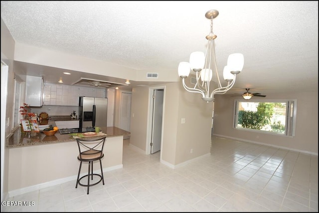 212 Paso Noble Dr, El Paso, TX 79912 - kitchen featuring stainless steel fridge, a peninsula, a textured ceiling, ceiling fan, and light tile patterned flooring