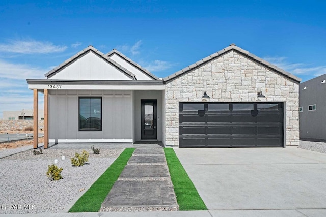 13399 Jeff Winton Dr, El Paso, TX 79928 - view of front facade featuring stone siding, an attached garage, concrete driveway, and a tiled roof