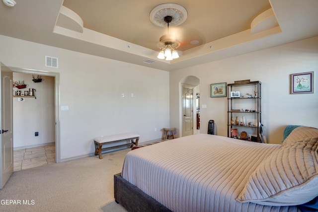 7301 Brays Landing Dr, El Paso, TX 79911 - bedroom featuring arched walkways, a raised ceiling, light carpet, baseboards, and a ceiling fan