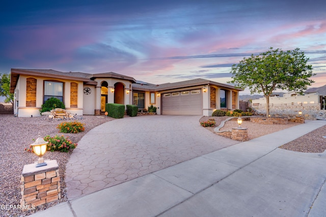 7301 Brays Landing Dr, El Paso, TX 79911 - view of front of house featuring an attached garage, decorative driveway, solar panels, and stucco siding