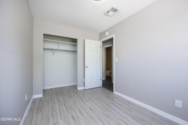 10704 Quartz St, El Paso, TX 79924 - unfurnished bedroom with wood finished floors, baseboards, a closet, and a textured ceiling