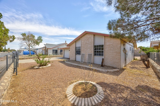 10704 Quartz St, El Paso, TX 79924 - back of property featuring brick siding, an attached garage, and concrete driveway