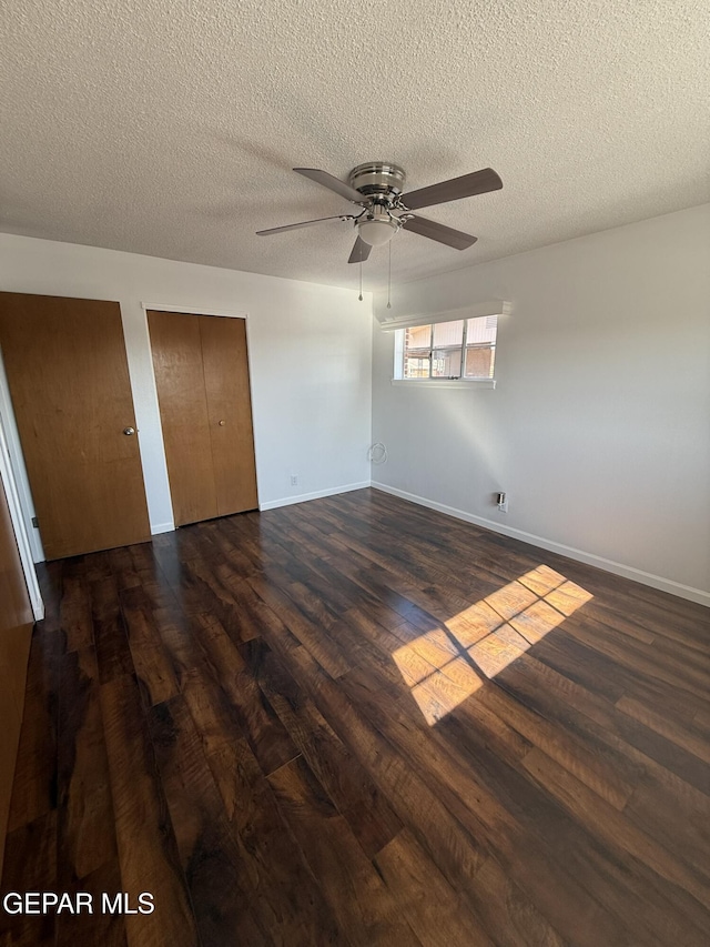 6220 Bel Mar Ave, El Paso, TX 79912 - unfurnished bedroom featuring wood finished floors, a textured ceiling, two closets, baseboards, and a ceiling fan