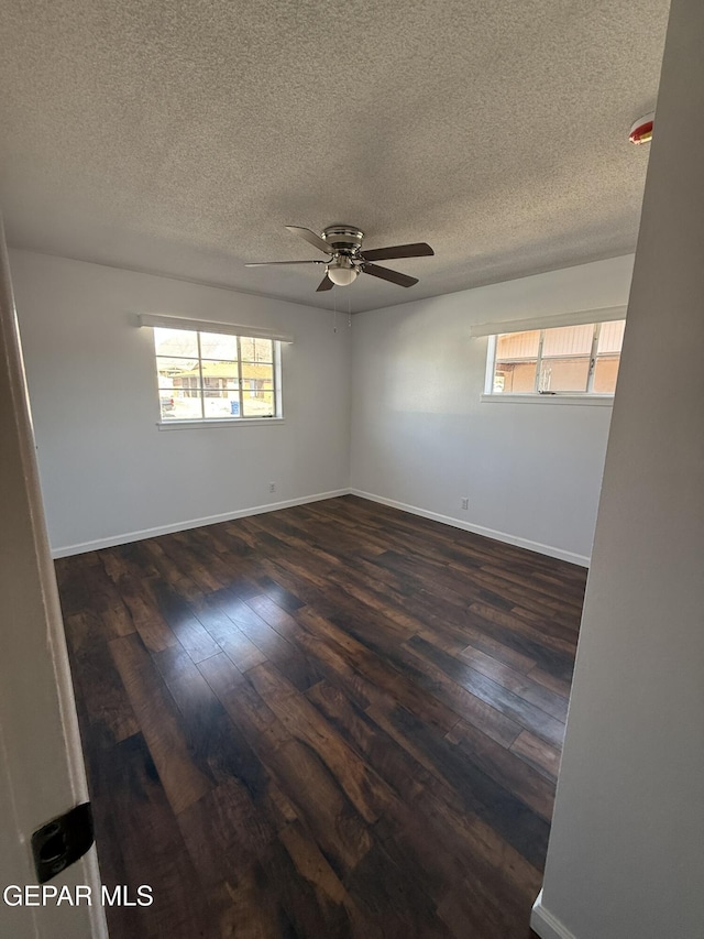 6220 Bel Mar Ave, El Paso, TX 79912 - spare room featuring ceiling fan, a textured ceiling, dark wood-type flooring, and baseboards