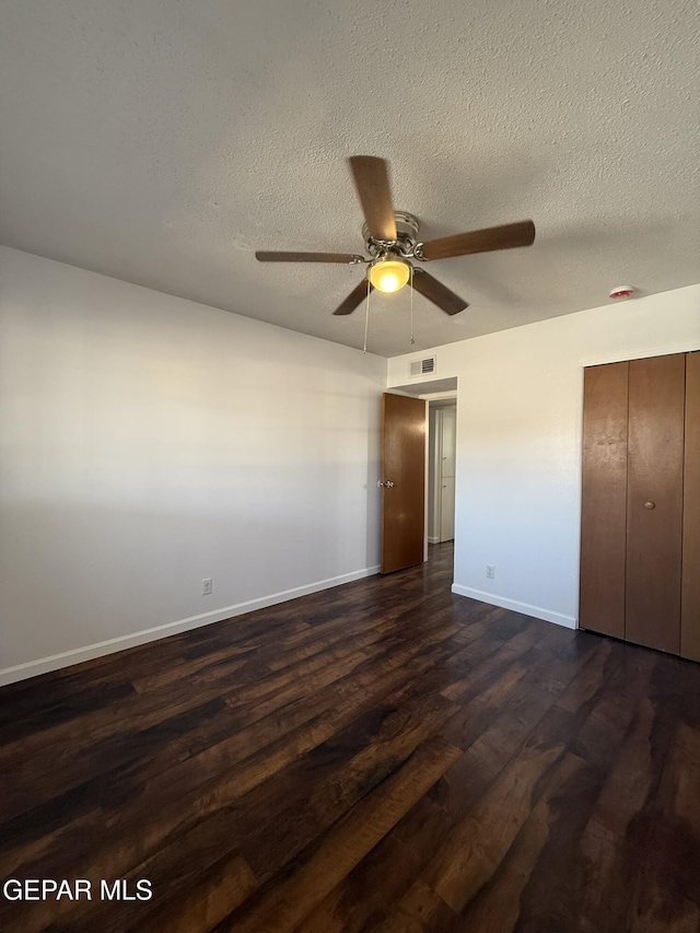 6220 Bel Mar Ave, El Paso, TX 79912 - unfurnished bedroom featuring baseboards, dark wood-type flooring, a textured ceiling, a closet, and ceiling fan