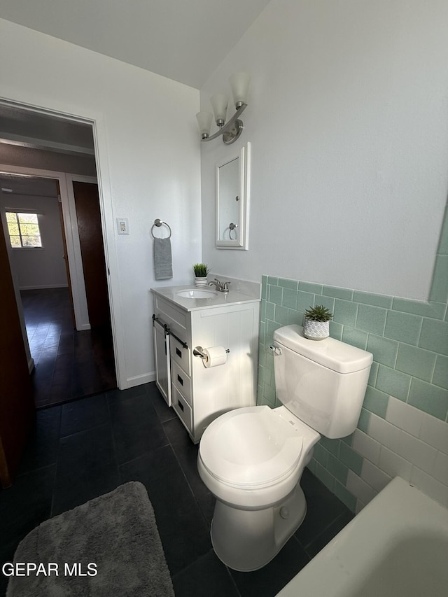 6220 Bel Mar Ave, El Paso, TX 79912 - full bathroom featuring vanity, tile patterned floors, toilet, a tub, and tile walls