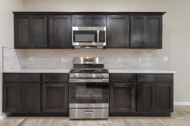 3800 Course, El Paso, TX 79938 - kitchen with stainless steel appliances, light countertops, wood finish floors, decorative backsplash, and dark brown cabinetry