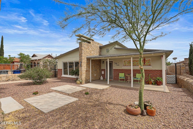 4012 Hastings Dr, El Paso, TX 79903 - back of property featuring brick siding, a patio area, and a gate