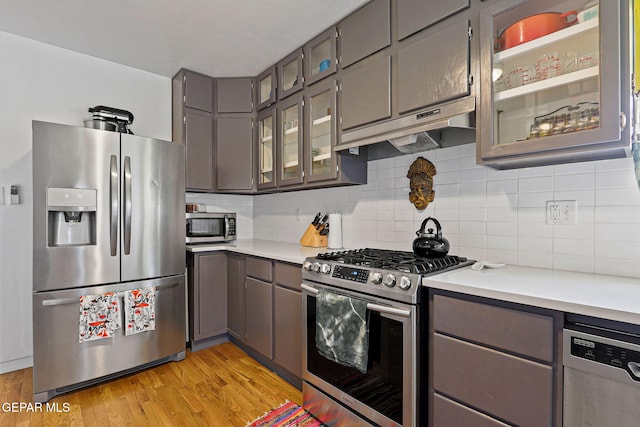 4012 Hastings Dr, El Paso, TX 79903 - kitchen with stainless steel appliances, gray cabinetry, under cabinet range hood, light countertops, and light wood-style flooring