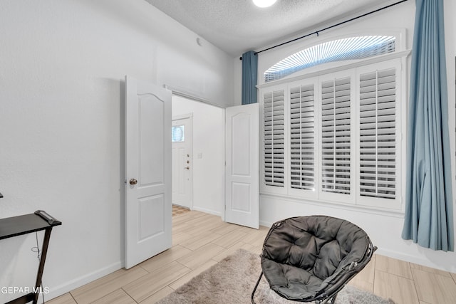 532 Gentry Way, El Paso, TX 79928 - sitting room featuring plenty of natural light, wood finish floors, a textured ceiling, and baseboards