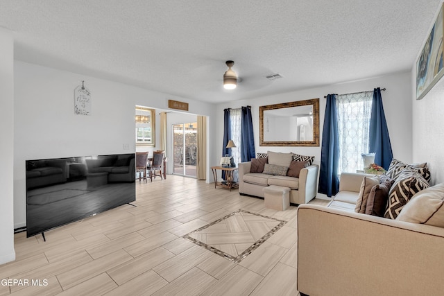 532 Gentry Way, El Paso, TX 79928 - living room featuring plenty of natural light, a textured ceiling, ceiling fan, and light wood-style flooring