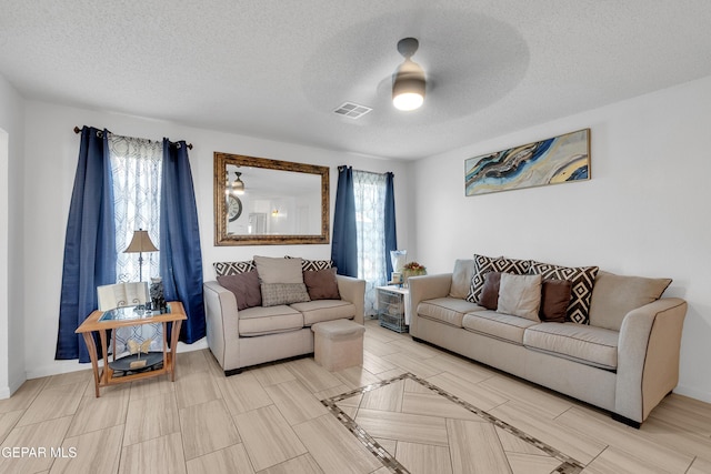 532 Gentry Way, El Paso, TX 79928 - living room featuring ceiling fan, plenty of natural light, a textured ceiling, and baseboards