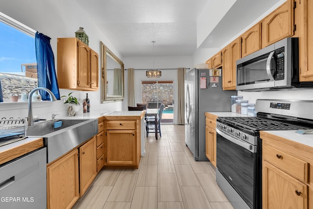 532 Gentry Way, El Paso, TX 79928 - kitchen with appliances with stainless steel finishes, light countertops, a peninsula, a sink, and decorative light fixtures