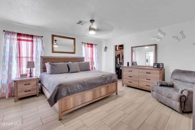 532 Gentry Way, El Paso, TX 79928 - bedroom featuring a spacious closet, a textured ceiling, a closet, and ceiling fan