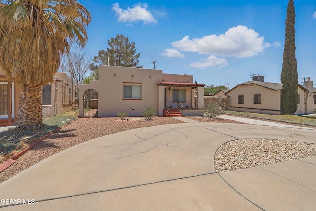 3408 Stanton St 233179, El Paso, TX 79902 - view of front of home featuring stucco siding, curved driveway, covered porch, and a tile roof