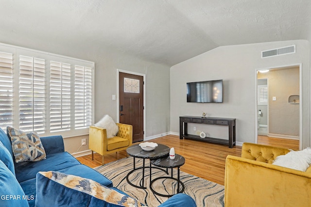 3408 Stanton St 233179, El Paso, TX 79902 - living room with vaulted ceiling, wood finished floors, healthy amount of natural light, baseboards, and a textured ceiling