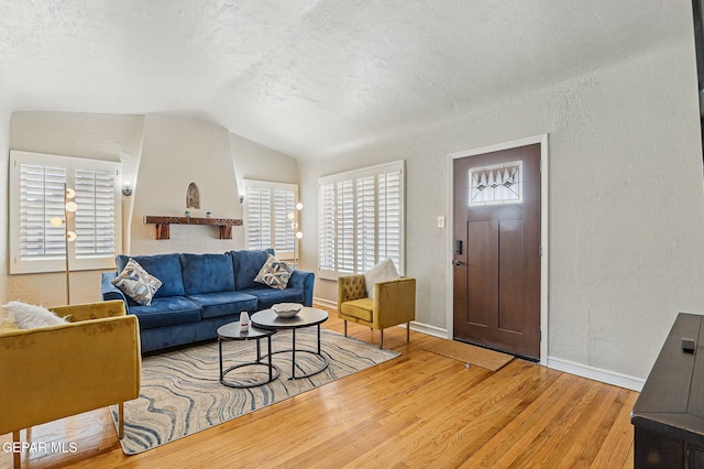 3408 Stanton St 233179, El Paso, TX 79902 - living area featuring a textured wall, wood finished floors, baseboards, and vaulted ceiling