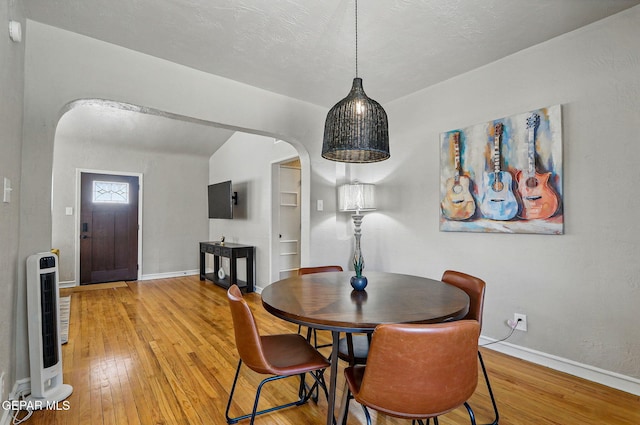 3408 Stanton St 233179, El Paso, TX 79902 - dining space featuring hardwood / wood-style flooring, heating unit, arched walkways, baseboards, and built in features