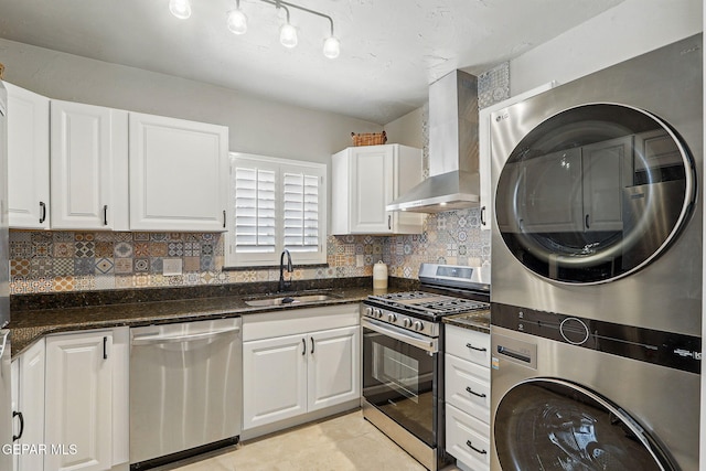 3408 Stanton St 233179, El Paso, TX 79902 - kitchen with stainless steel appliances, wall chimney range hood, a sink, stacked washer / drying machine, and white cabinetry
