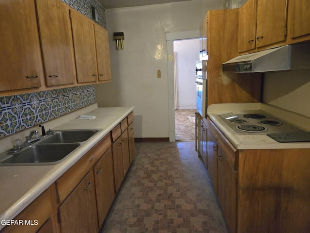 3812 Wilson Way, El Paso, TX 79903 - kitchen with under cabinet range hood, a sink, light countertops, brown cabinets, and electric stovetop