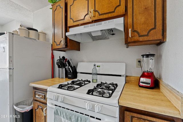8957 Robert Dr Unit A & B, El Paso, TX 79904 - kitchen featuring white appliances, under cabinet range hood, brown cabinets, and a textured ceiling