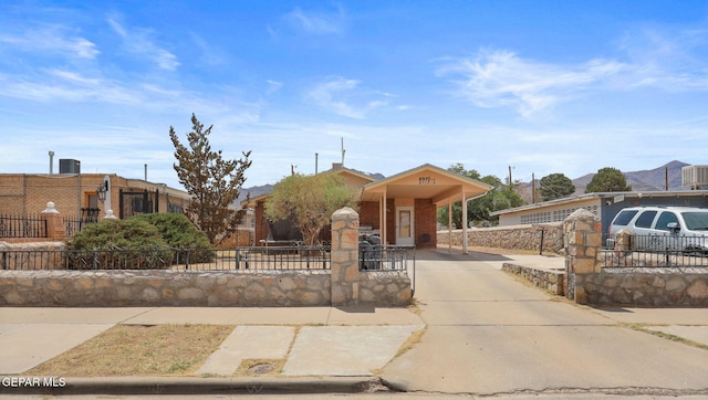 8957 Robert Dr Unit A & B, El Paso, TX 79904 - view of front of house with a fenced front yard, central AC, driveway, and brick siding