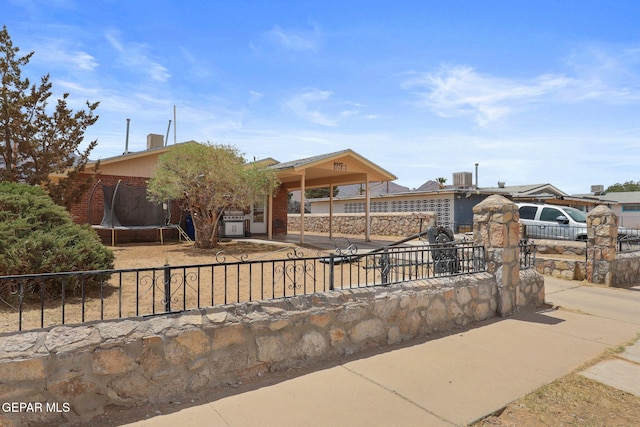 8957 Robert Dr Unit A & B, El Paso, TX 79904 - view of front of home with a fenced front yard, driveway, and a trampoline