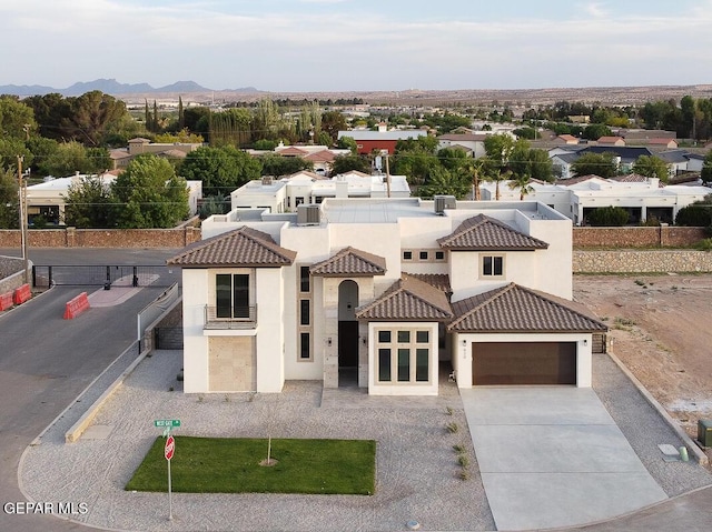 820 W Gate, El Paso, TX 79932 - mediterranean / spanish house featuring stucco siding, concrete driveway, a tiled roof, and a garage