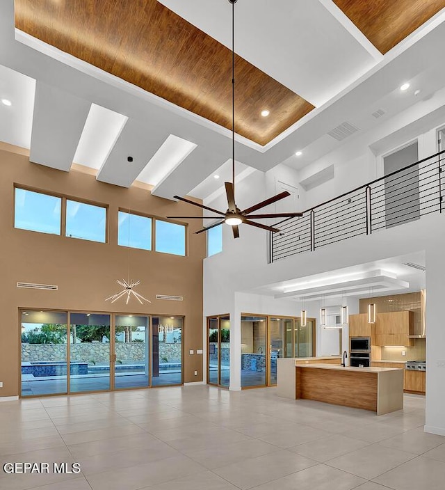 820 W Gate, El Paso, TX 79932 - unfurnished living room featuring a towering ceiling, wood ceiling, a ceiling fan, light tile patterned flooring, and recessed lighting