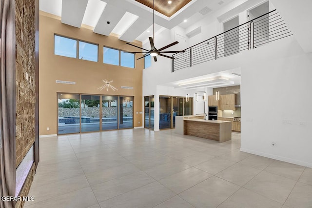 820 W Gate, El Paso, TX 79932 - unfurnished living room with a high ceiling, ceiling fan, light tile patterned floors, and baseboards