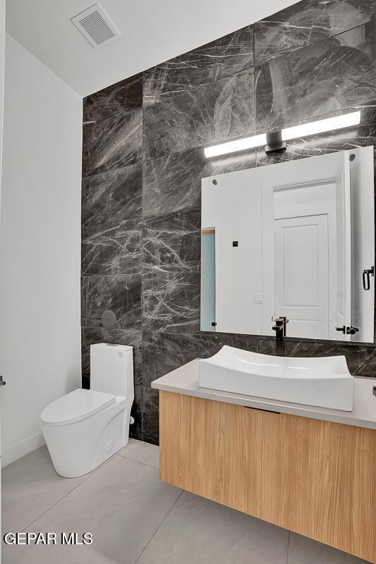 820 W Gate, El Paso, TX 79932 - bathroom featuring toilet, vanity, and tile walls