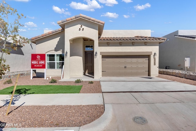 13404 Coldham St, El Paso, TX 79928 - mediterranean / spanish house with a tile roof, concrete driveway, an attached garage, and stucco siding