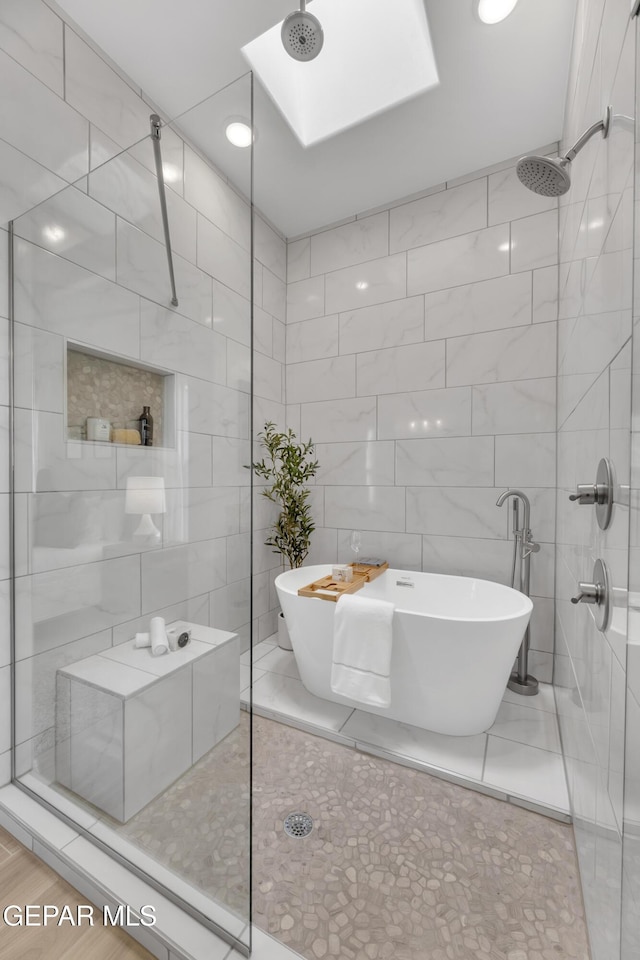 13404 Coldham St, El Paso, TX 79928 - bathroom featuring tile walls, tiled shower, a freestanding tub, and a skylight